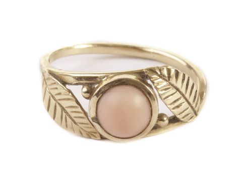 A French 15ct gold and coral ring, having two leaves and cabochon pink coral bead to tablet, marked to rear 