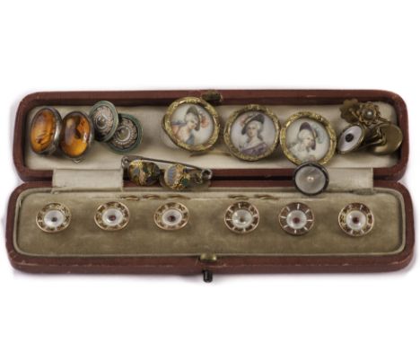 A set of six mother of pearl and enamel dress studs, with gold and red enamel rims and centred with a red cut stone, AF, in f