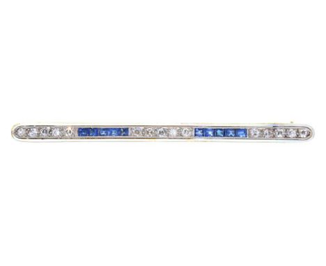 AN EDWARDIAN CALIBRE SAPPHIRE AND SINGLE CUT DIAMOND BAR BROOCH IN GOLD WITH WHITE ENAMEL SURROUND, 6.2 CM L, MARKED 18CT &am