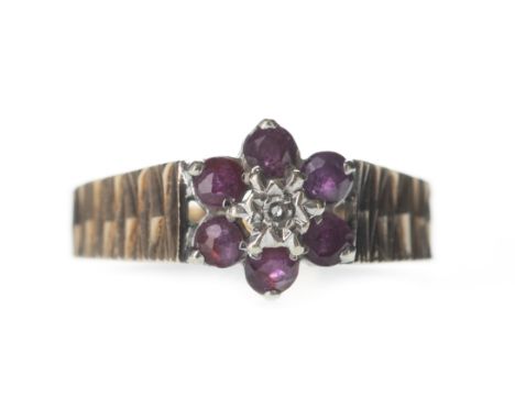 RED GEM SET AND DIAMOND CLUSTER RING, set with a central round brilliant cut diamond of approximately 0.03 carats, within a h