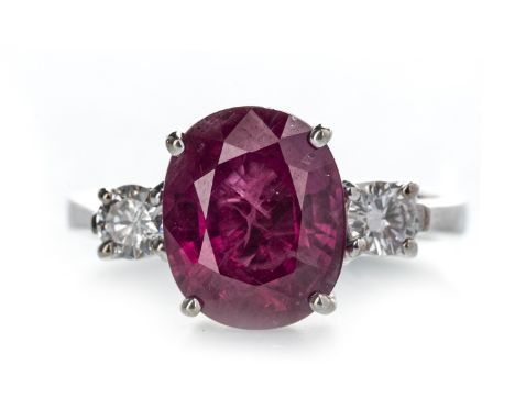 RUBY AND DIAMOND THREE STONE RING, the central oval ruby of approximately 4.34 carats flanked by two round brilliant cut diam