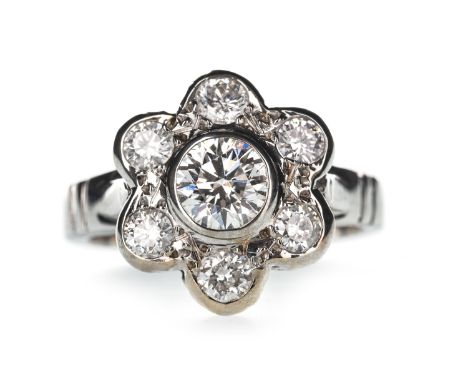 DIAMOND FLOWER RING, set with a central round brilliant cut diamond of approximately 0.75 carats, surrounded by smaller diamo