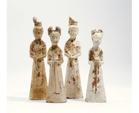 Four Chinese unglazed pottery figures of ladies, each simply dressed in a long robe and shawl, with hair drawn up, with trace