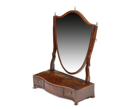 A George III mahogany dressing table mirror, with a shield shape plate and brass urn finials, the serpentine box base fitted 