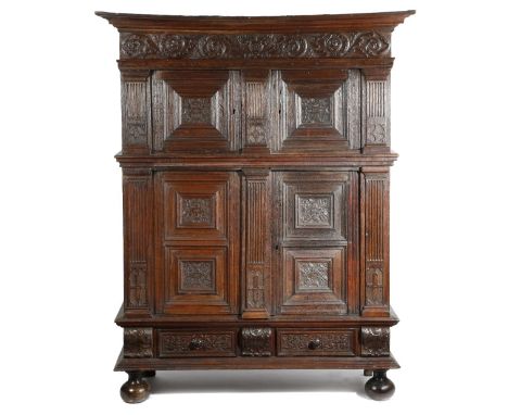 A late 17th century Flemish oak cupboard, the moulded cornice above a frieze carved with scrolling leaves, above a pair of do