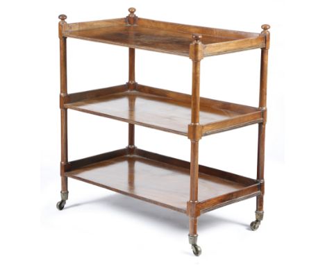 A Regency mahogany three-tier buffet, the galleried top with turned finials, with reeded decoration, on brass caps and castor