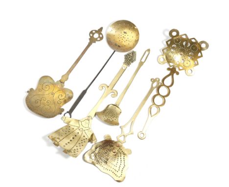 Six brass dairy skimmers, with pierced decoration, one in the form of a bishop, the handle with a mitre finial, another circu