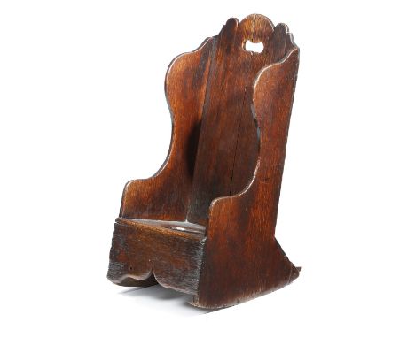 A George III fruitwood child's rocking commode chair, pierced with a handgrip.
