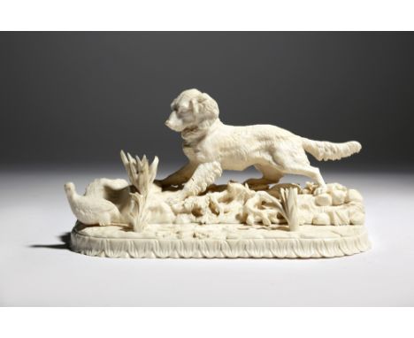 λ A 19th century ivory animalier group after Pierre-Jules Mêne, carved with a spaniel hunting a game bird, on a naturalistic 