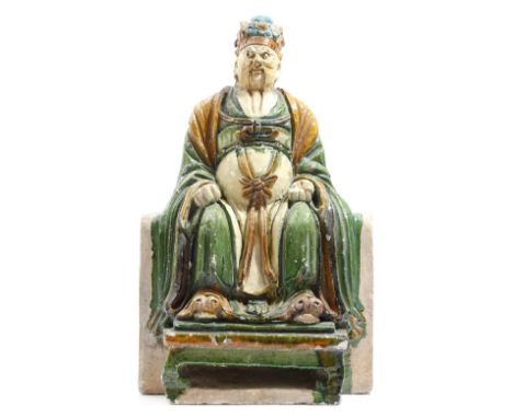 A Chinese pottery tile maker's figure of the immortal Tudi, with sancai glaze, the seated dignitary with his feet on a low st