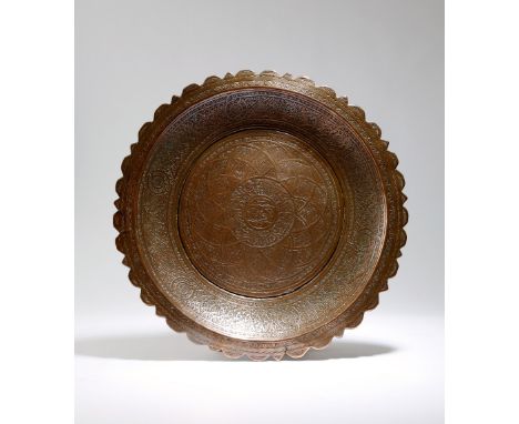 An early 16th century Mamluk copper dish, with a lobed rim and inner bands of scrolling leaves and elliptical designs on a ge