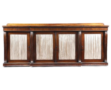 λ A Regency rosewood breakfront side cabinet, the top with a raised back, above two frieze drawers and three cupboards with p