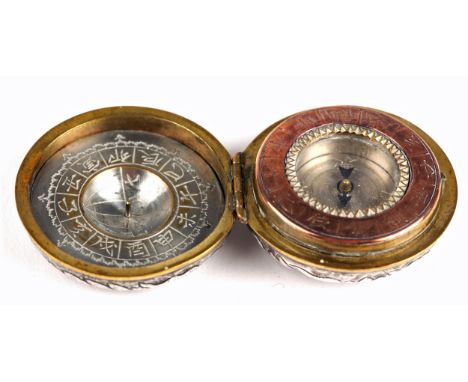 An oriental silver-cased combination compass and sundial, the compass with engraved copper bezel opposite a silvered brass su