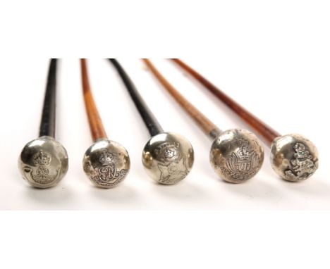 A collection of five British and Indian Army regimental swagger sticks, each with a white metal cap, relief decorated with th