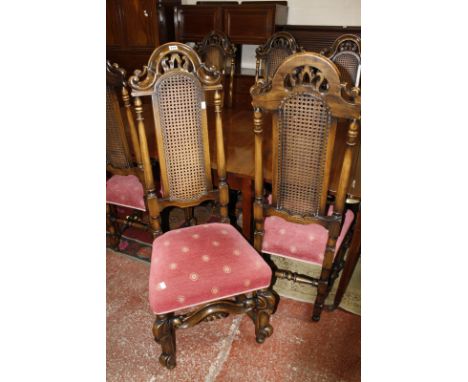 A set of eight Charles II style oak and cane high back dining chairs to include two armchairs, each with arched and scroll ba