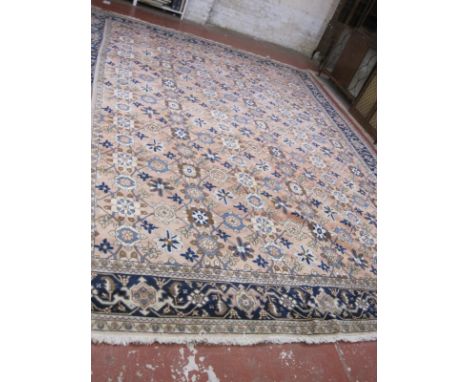 A North West Persian carpet, the pink field with allover flowerheads, palmettes and tendrils within an indigo floral border a