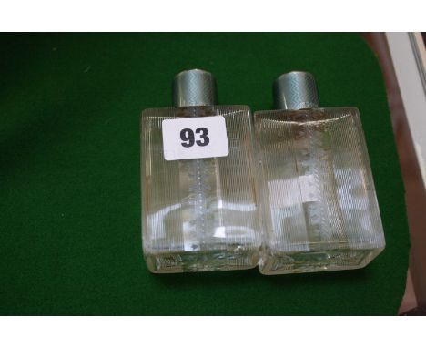 A pair of Art Deco glass perfume bottles with silver and green enamel lids, Birmingham 1931