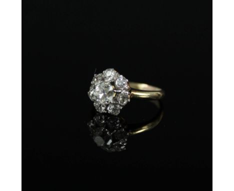 An 18ct gold diamond cluster ring, the central diamond approx 0.5cts in raised seven claw setting with seven smaller diamond 