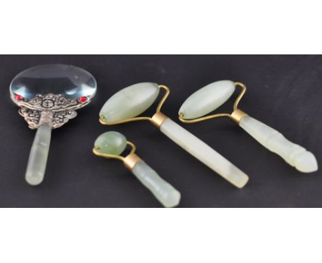Three jade massage rollers, together with a white metal mounted magnifier with jade handle (4)