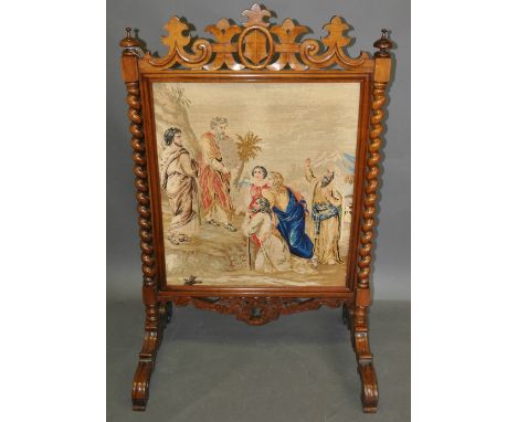 A Victorian faded rosewood firescreen with pierced pediment over a polychrome tapestry panel on carved scroll feet