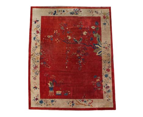 A CHINESE RED GROUND CARPET c.1930, having a bird resting on a branch with blossom within an ivory border, 270cm x 350cm