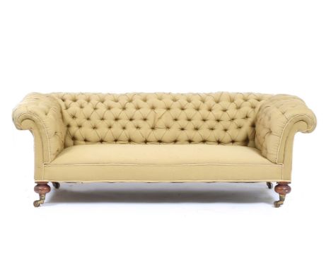A VICTORIAN CHESTERFIELD SETTEE with scroll arms, deep button green upholstery and on mahogany turned legs and brass wheel ca