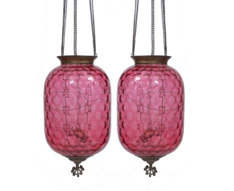 A PAIR OF CRANBERRY GLASS OVOID HANGING LIGHT FITTINGS with honeycomb moulded pattern to the glass and with pierced finials b