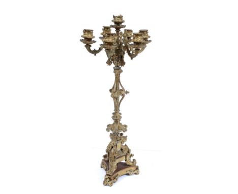 AN ANTIQUE GILT BRASS SEVEN LIGHT CANDELABRUM with six scrolling branches, the central stem decorated with fawn masks, fruit 