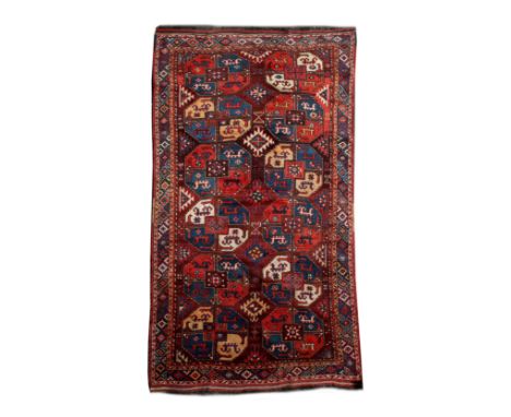 A CENTRAL ASIAN RED GROUND HALL CARPET decorated with two rows of interlinked octagonal medallions within a geometric border,