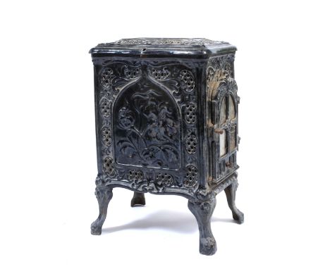 AN OLD FRENCH BLACK ENAMEL WOOD BURNING STOVE, with floral decoration and standing on cast bracket feet, 41cm front to back x