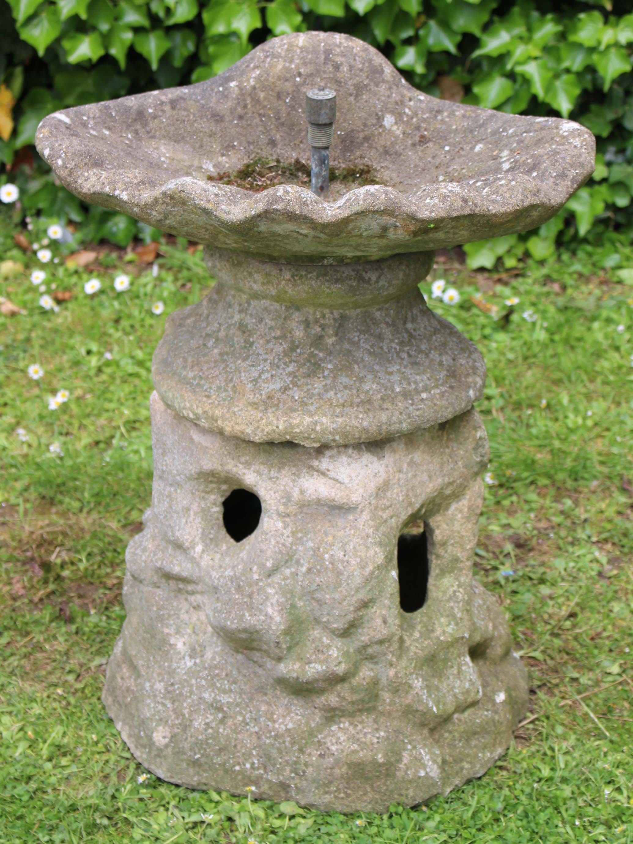 AN OLD CAST CONCRETE FOUNTAIN with shell moulded top and rusticated