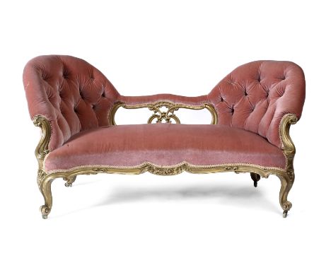 A VICTORIAN GILT FRAMED CARVED WOOD SOFA the twin button upholstered ends flanked by a pierced carved support with scrolling 