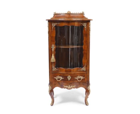 A FRENCH WALNUT SERPENTINE FRONTED VITRINE, the shaped top with brass gallery, a glazed single door to the front enclosing a 