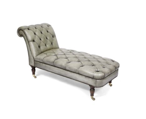 A GREEN BUTTON LEATHER UPHOLSTERED CHAISE LONGUE with scrolling end and turned legs terminating in brass casters, 170cm long