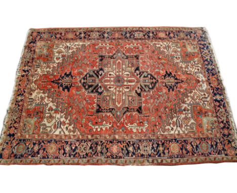 A HEREZ BRICK RED GROUND CARPET with a central star medallion and within a wide blue ground border (cut), 348cm x 245cm