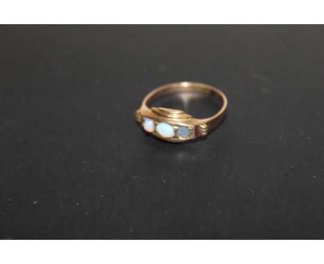 AN UNMARKED YELLOW METAL THREE STONE OPAL STYLE RING 