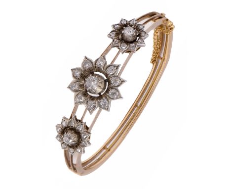 A Victorian diamond bangle, with three sunflower shaped diamond clusters, in silver on gold bangle, 60mm wide (internal), 22.