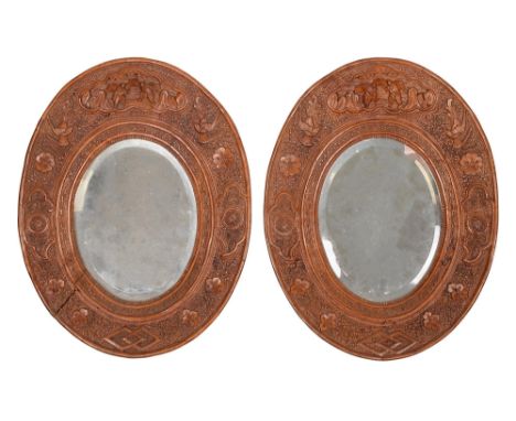A pair of Chinese carved sandalwood oval mirrors, 19th c, 34.5cm h (2)  One mirror with two splits to frame
