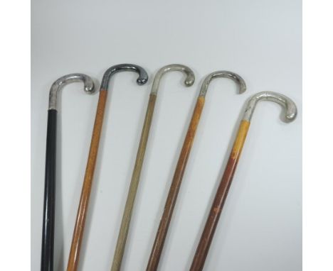 An early 20th century continental silver handled walking stick, with engraved decoration and an ebonised shaft, together with