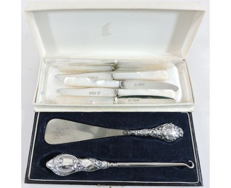 A silver button hook and shoe horn, cased, together with a set of six silver fruit knives, with mother of pearl handles 