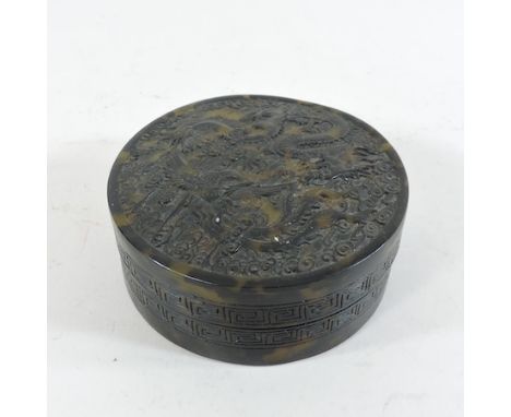 A Chinese faux tortoiseshell carved circular trinket box, 10cm diameter