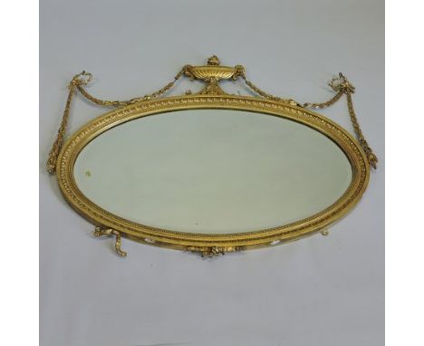 A 19th century carved pine and gilt gesso framed wall mirror, the bevelled oval plate within a moulded surround, surmounted b