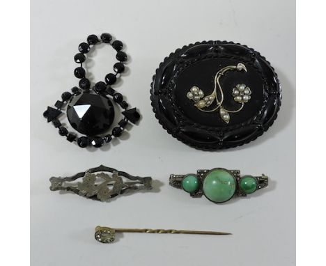 A Victorian jet mourning brooch, together with another, cased, an early 20th century cabochon brooch, a silver brooch and a s