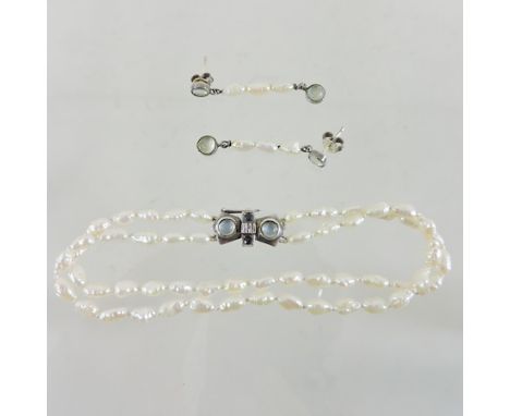 A seed pearl two row bracelet with a moonstone clasp, together with a pair of earrings, cased 