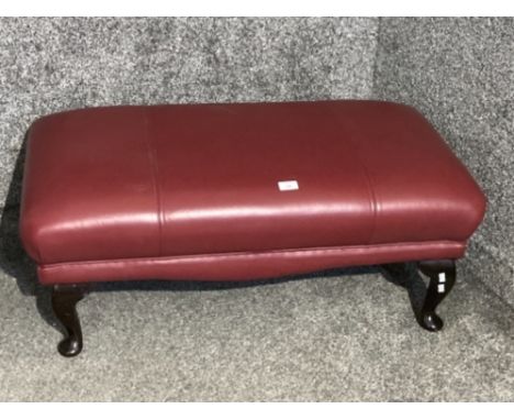 A red leatherette pouffe