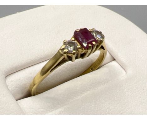 Ladies 18ct gold ruby and diamond ring. Set with emerald cut ruby and 2 round brilliant cut diamonds set either side. 2g size