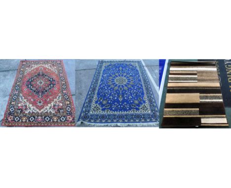 Three machine woven rugs, red ground, 285cm x 199cm, blue ground, 280cm x 198cm, and brown ground, 163cm x 108cm. Buyer Note: