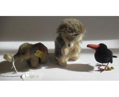 Three small Steiff plush characters, comprising a 4 1/2" hedgehog with felt pads, a 4 1/4" elephant with felt pads and saddle