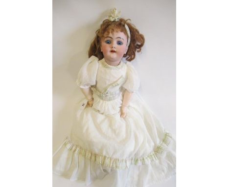 A Heinrich Handwerck bisque socket head doll, with blue glass fixed eyes, open mouth, applied teeth, pierced ears, auburn wig