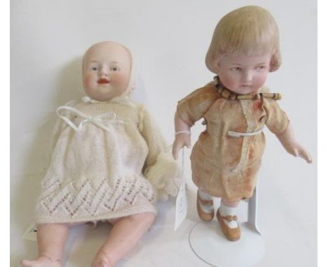 Two all bisque five piece jointed dolls, comprising a standing Gebruder Heubach girl, with moulded hair, sideways glancing ey